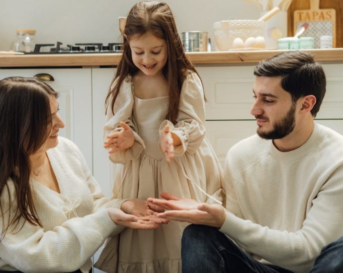 A group of people sitting around in a kitchen